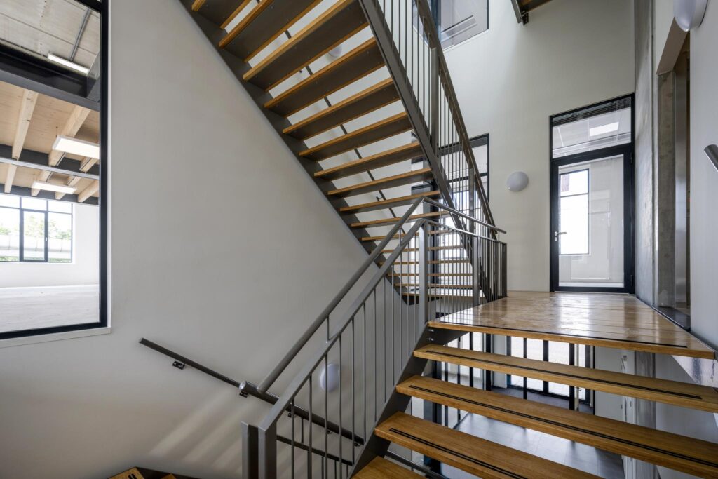 Modern indoor staircase with wooden steps and metal railings in a commercial building on Paul van Vlissingenstraat.